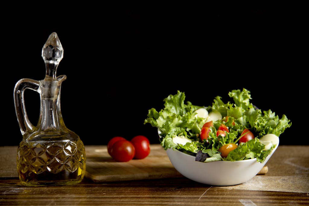 Vitamin vegetable salad on table with bottle of oil