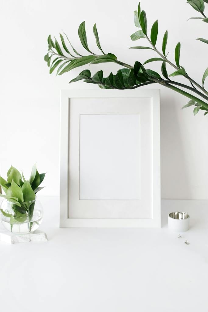 Empty photo frame on desk decorated with green plants
